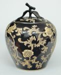 Potiche oriental em porcelana na forma de maça, com decoração de flores e folhagens sobre fundo preto - med. 23 cm.