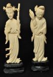 Lote constando de duas esculturas orientais esculpidas em marfim, representando gueixas com bases em madeira entalhada - med. 9,5 cm e 10 cm com base med. 11,5 e 12 cm.