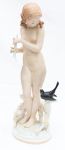 Delicada escultura de porcelana alemã representando mulher com pássaro. Med. 33cm alt