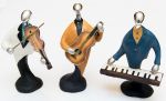 Conjunto em resina multicolorido representando 3 musicistas (violino, violão e orgão). Alt. 14cm