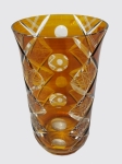 Vaso em cristal da Bohemia na cor ambar, lapidado com faixas entrelaçadas com detalhes em estrelas ao centro e bolas. Altura de 22 cm.
