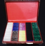 Caixa com antigas fichas para jogo, peroladas em diversas cores:  30 brancas (1,00) - 20 azulão (10,00) - 20 douradas (20,00) - 16 lilás (5,00) - 19 amarelas (50,00) - 39 pretas (0,50) - 37 verdes (2,00). Acompanha estojo com desgaste de uso.