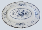 Travessa oval em ágata esmaltada com desenho de flores em azul royal com marca na base. Mede 50 x 35 cm.