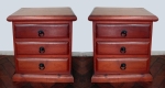 Par de mesas de cabeçeira em madeira avermelhada com 3 gavetas e puxadores em forma de argolas. No estado, com medidas de 45 x 30 cm com 55 de altura.