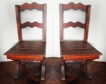 Par de cadeiras em madeira encerada, assento ripado e pés em forma de X ambas com desgastes de uso. Assento com 45 x 40 cm e altura de 90 cm.