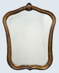 Espelho bisotado, década de 50, com moldura de madeira ondulada e folheada à ouro. Mede 60 x 50 cm e na parte menor inferior, 35 cm.
