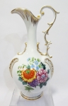Ânfora em porcelana branca esmaltada e desenhos ao estilo françês em desenhos de flores e detalhes à ouro e afrescos. Altura de 25 cm.