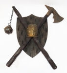 Escudo em madeira esculpida com 2 armas em estilo medieval com detalhes em ferro fundido. Mede 55 x 50 cm.