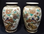 Belo par de vasos em antiga porcelana japonesa, Satzuma com desenhos de aves do paraíso e flores em ricos relevos. Bordas negras com detalhes em ouro.  Altura de 40 cm.